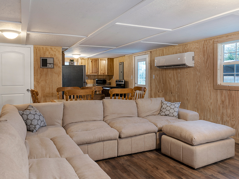 The living room area with a view of the kitchen behind it